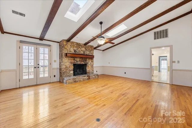 a view of empty room with wooden floor and fireplace