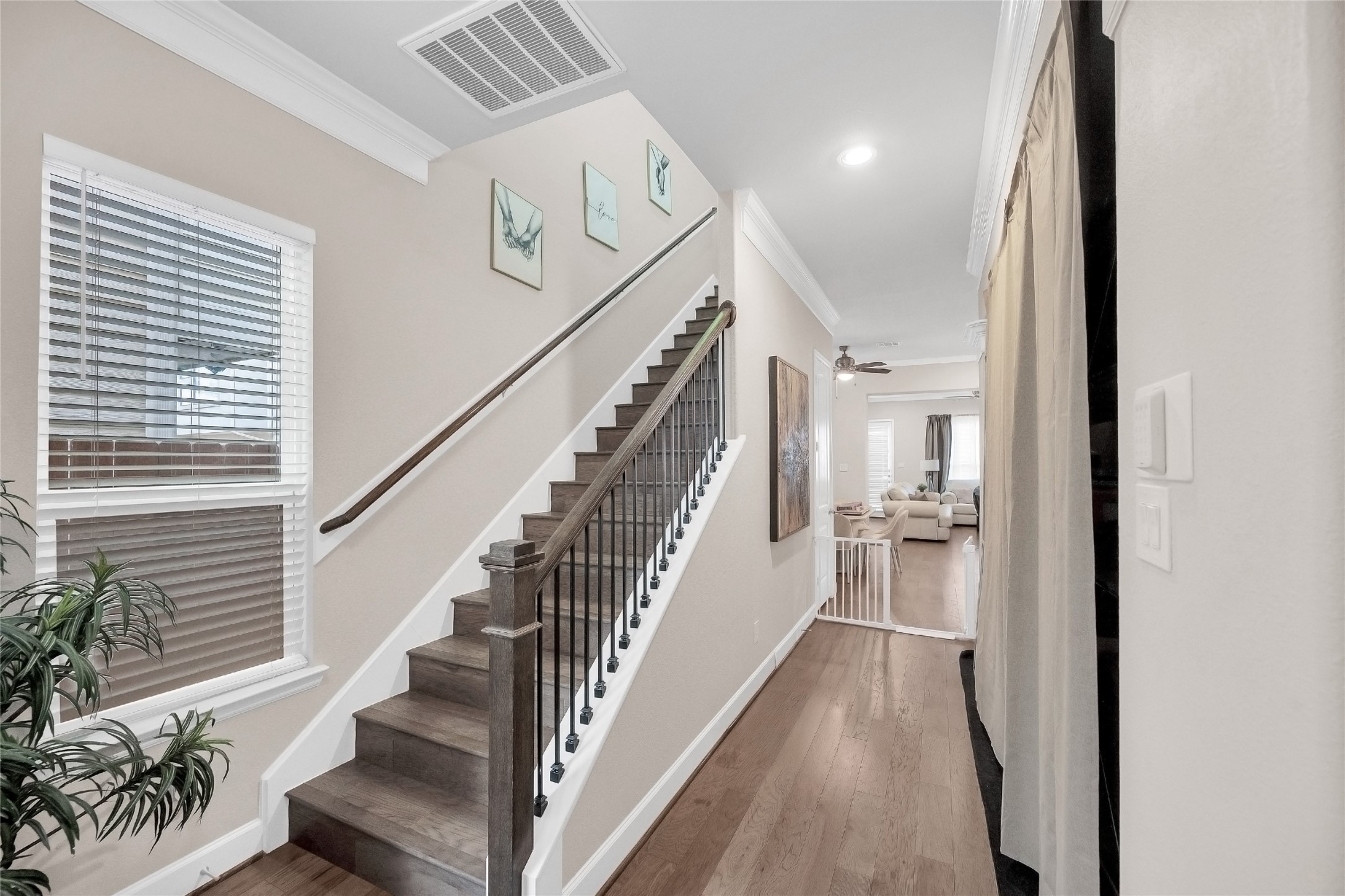 5014 Lillian Street Houston, TX 77007 - Photo 3 of 24 a view of staircase with lots of frames on wall and wooden floor