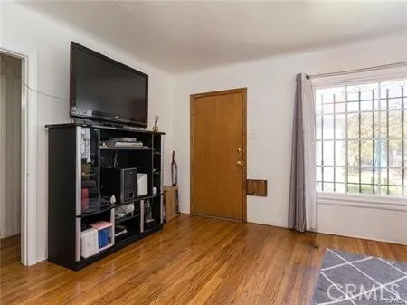 a view of a livingroom with wooden floor and a flat screen tv