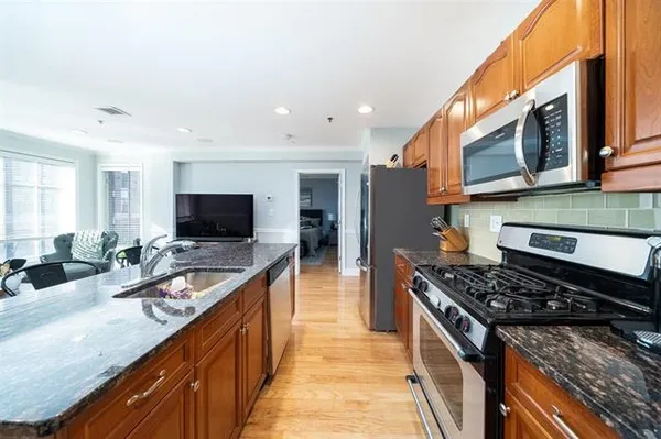 a kitchen with stainless steel appliances granite countertop a stove and a sink