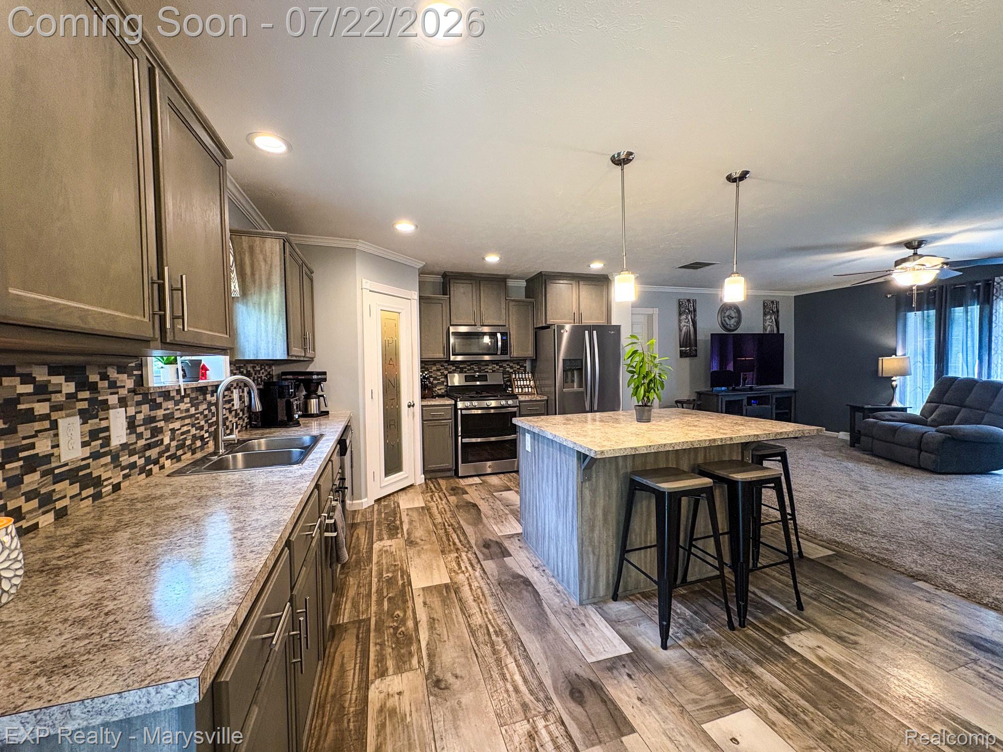 2601 Beach Road Port Huron, MI 48060 - Photo 12 of 34 Contemporary kitchen featuring gray cabinetry, stainless steel appliances, and a mosaic tile backsplash