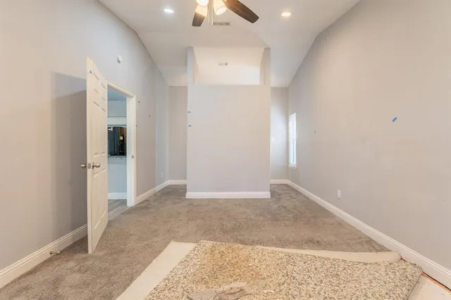 an empty room with fan and entrance