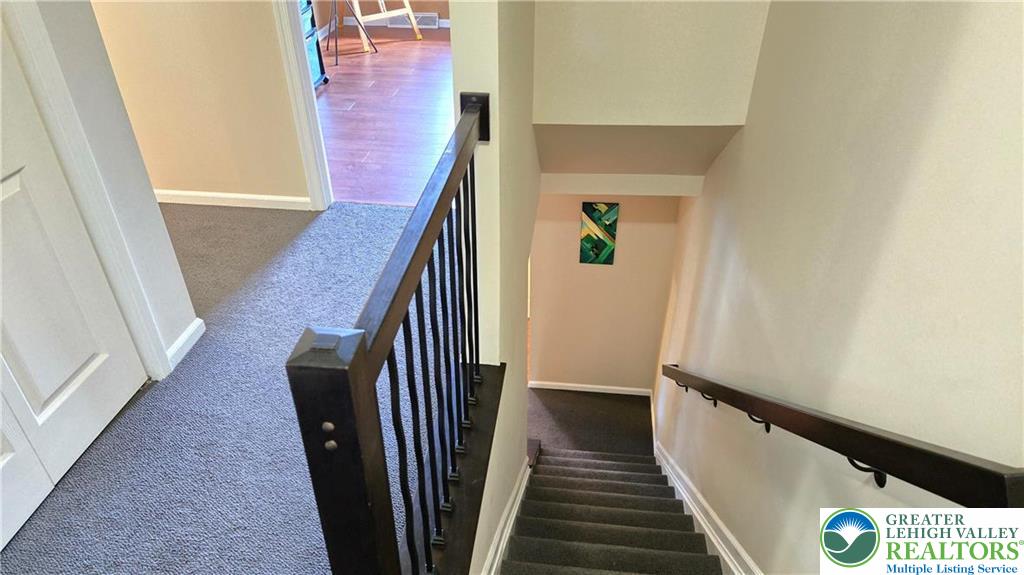 194 Springhouse Road Allentown, PA 18104 - Photo 28 of 34 This interior staircase features durable carpeted treads and sleek railings, ensuring safe and easy movement between floors.