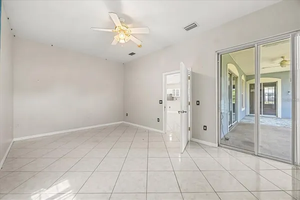 an empty room with fan and glass door