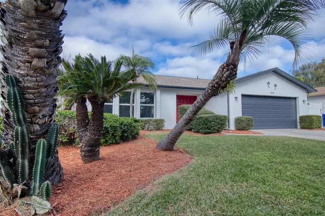 a front view of a house with a yard and potted plants