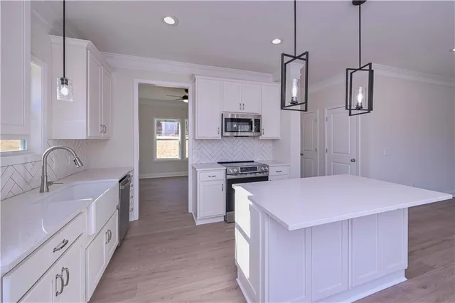 a kitchen with kitchen island a sink stove and refrigerator