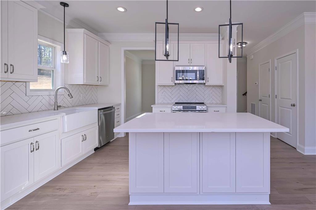 262 Corinth-Five Points Road Buchanan, GA 30113 - Photo 15 of 41 a kitchen with kitchen island white cabinets stainless steel appliances and a center island