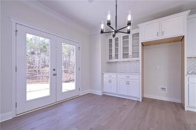 an empty room with wooden floor cabinet and windows