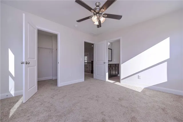 an empty room with closet and a ceiling fan