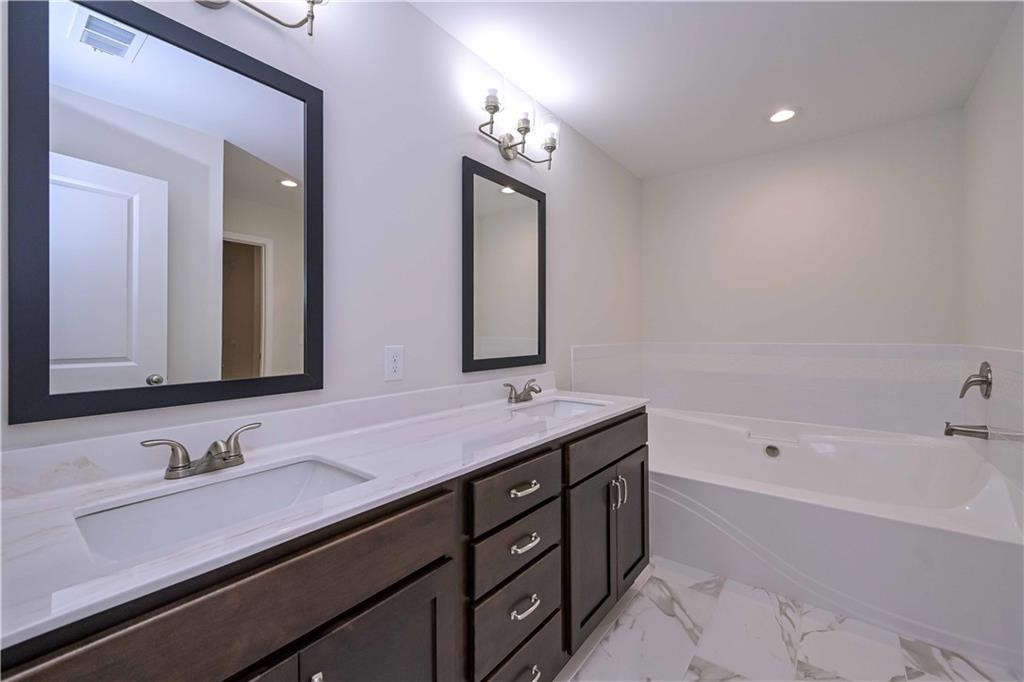 262 Corinth-Five Points Road Buchanan, GA 30113 - Photo 33 of 41 a bathroom with a granite countertop sink mirror and bathtub