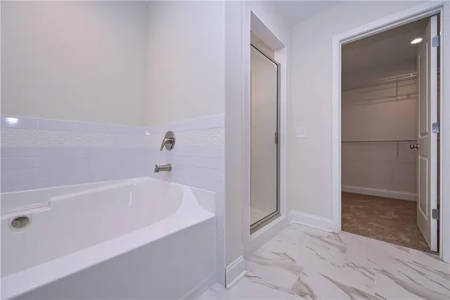 a white bath tub sitting in a bathroom near shower