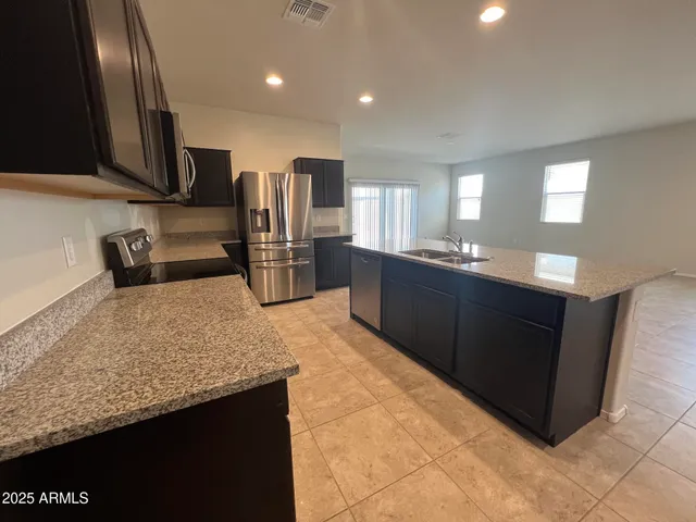 a kitchen with stainless steel appliances granite countertop a refrigerator and a sink