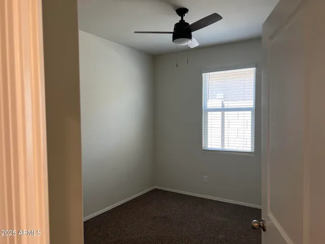 an empty room with a window and a fan