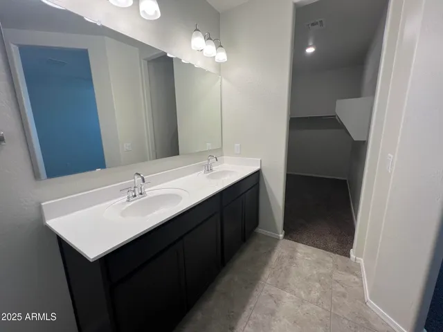 a en suite bathroom with a sink double vanity and a mirror