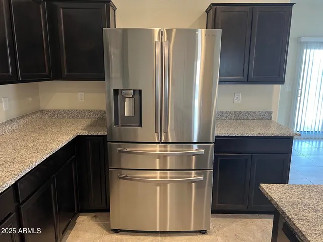 a kitchen with stainless steel appliances granite countertop a refrigerator and a stove top oven