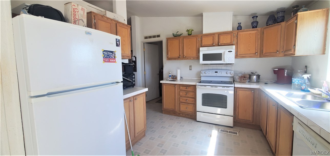 5809 Elfrida Road Golden Valley, AZ 86413 - Photo 19 of 64 a kitchen with a refrigerator sink and cabinets