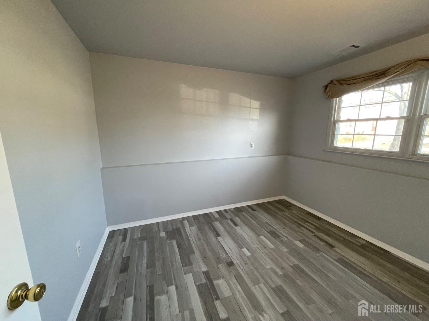 57 Greenbrook Road Middlesex, NJ 08846 - Photo 3 of 18 an empty room with wooden floor and windows