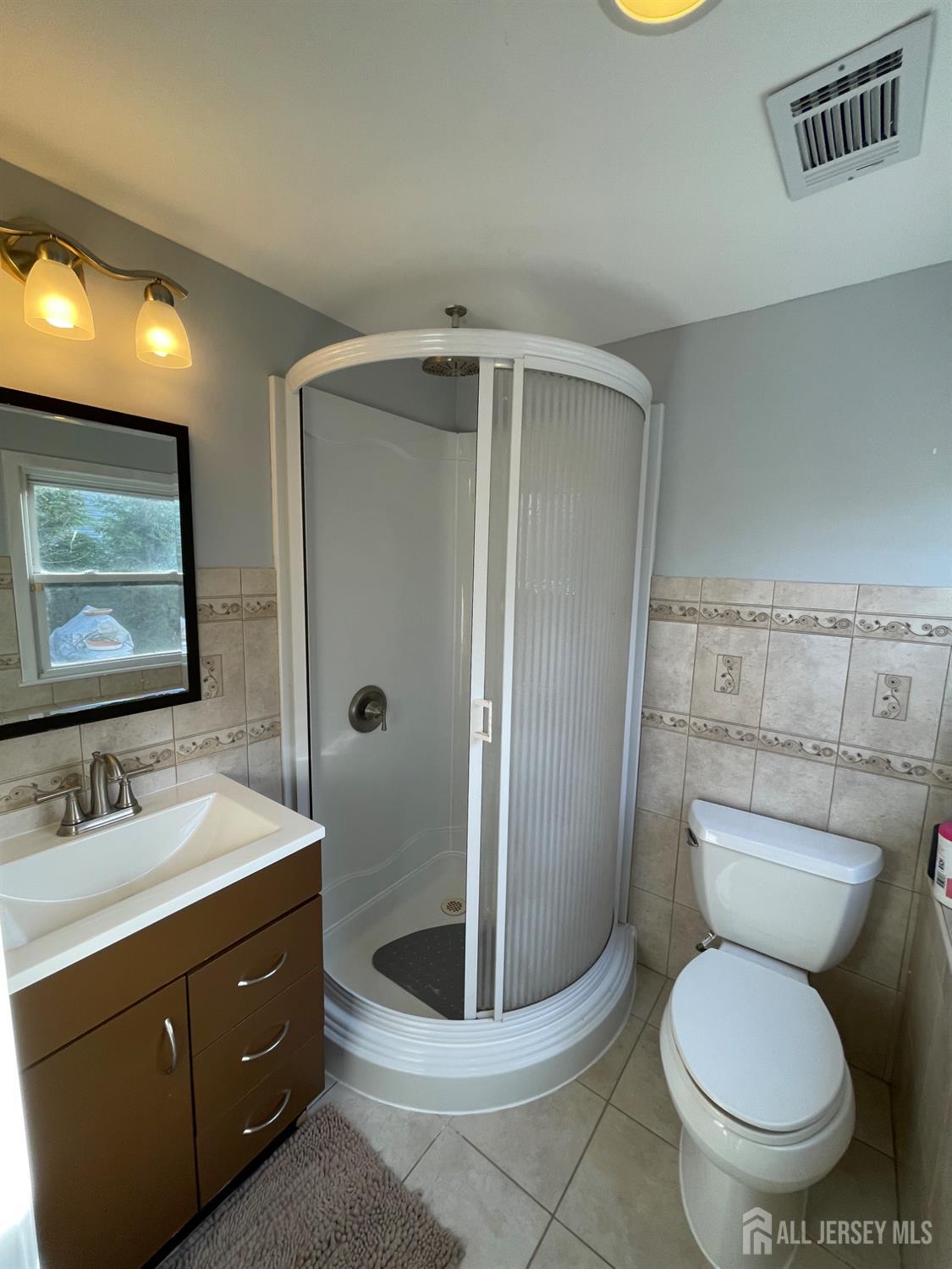 57 Greenbrook Road Middlesex, NJ 08846 - Photo 6 of 18 a bathroom with a toilet a sink and mirror