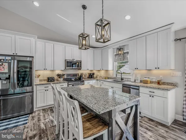 a kitchen with a center island and stainless steel appliances