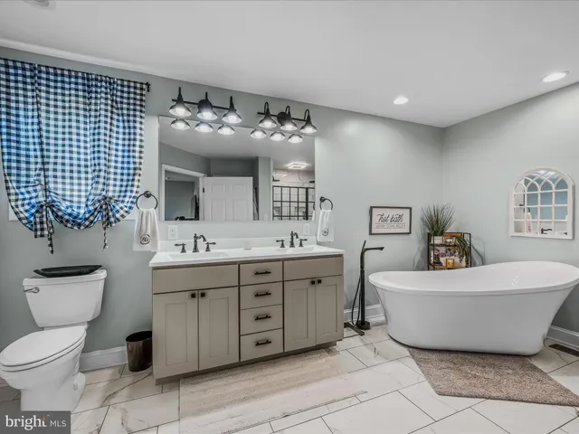 a spacious bathroom with a toilet sink and mirror