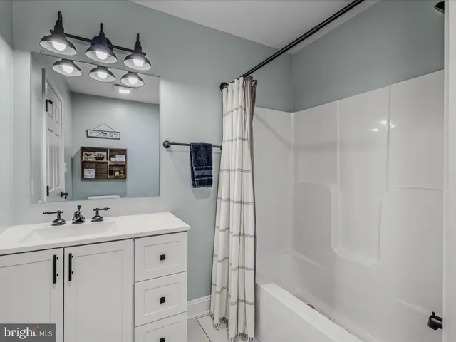 a bathroom with a sink vanity tub and shower