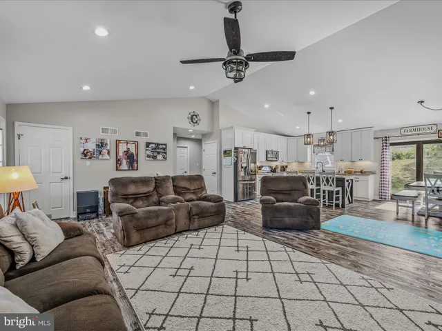 a living room with lots of furniture and kitchen view