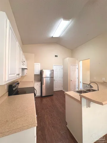 a view of kitchen with refrigerator stove and window