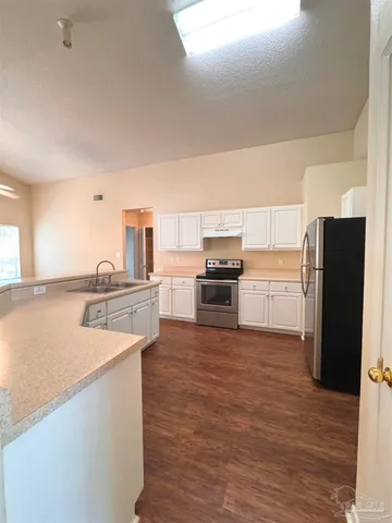 a kitchen with stainless steel appliances granite countertop a refrigerator and a sink