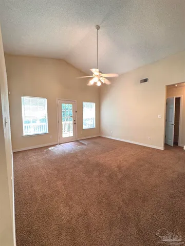 en empty room with windows and chandelier fan