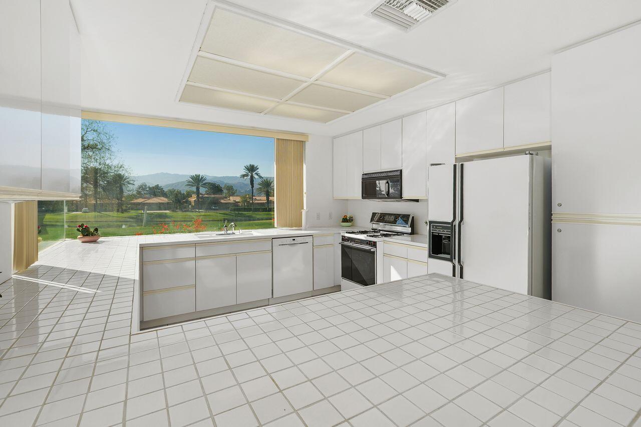 31 Pebble Beach Drive Rancho Mirage, CA 92270 - Photo 14 of 49 a kitchen with granite countertop a refrigerator and a stove top oven