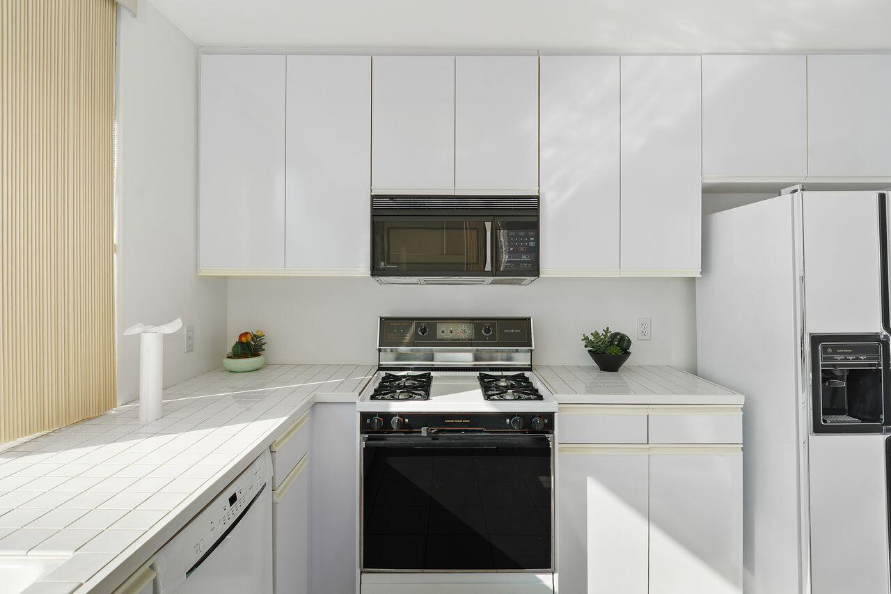 31 Pebble Beach Drive Rancho Mirage, CA 92270 - Photo 15 of 49 a kitchen with a sink a stove and cabinets