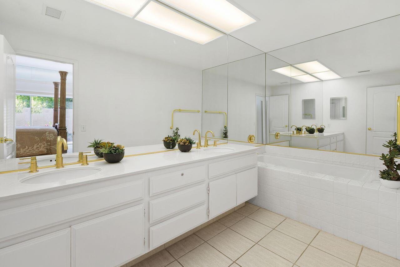 31 Pebble Beach Drive Rancho Mirage, CA 92270 - Photo 20 of 49 a spacious en suite bathroom with a double vanity sink and a mirror
