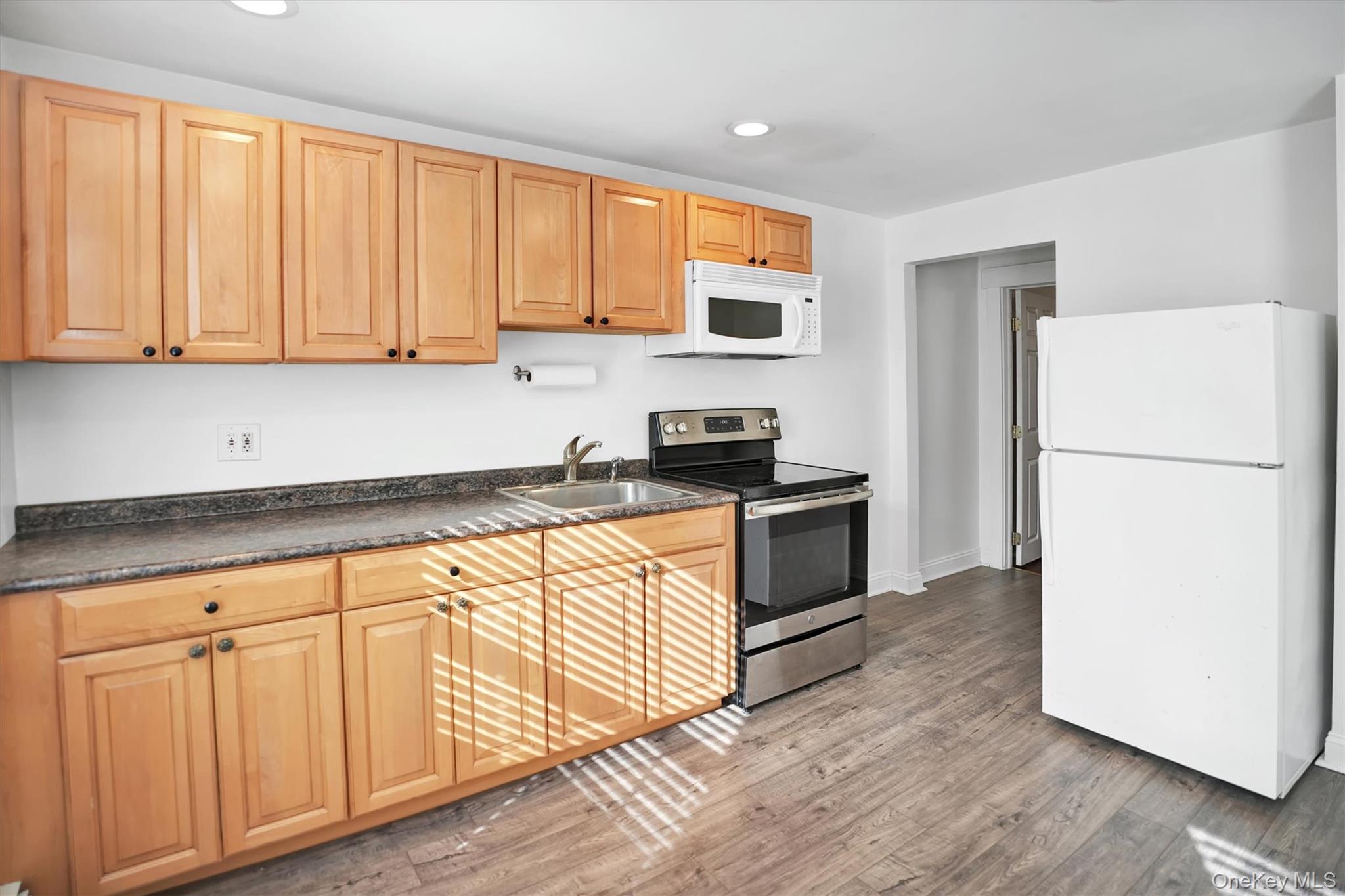 14 Halsey Avenue East Quogue, NY 11942 - Photo 11 of 23 a kitchen with granite countertop white cabinets and refrigerator