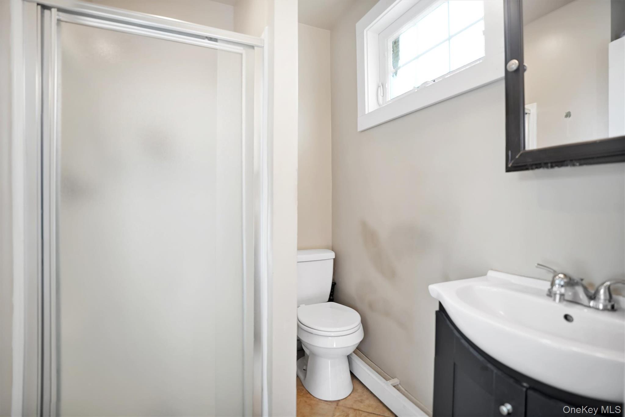 14 Halsey Avenue East Quogue, NY 11942 - Photo 17 of 23 a bathroom with a toilet a sink and a mirror