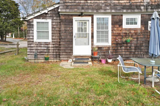 a backyard of a house with table and chairs