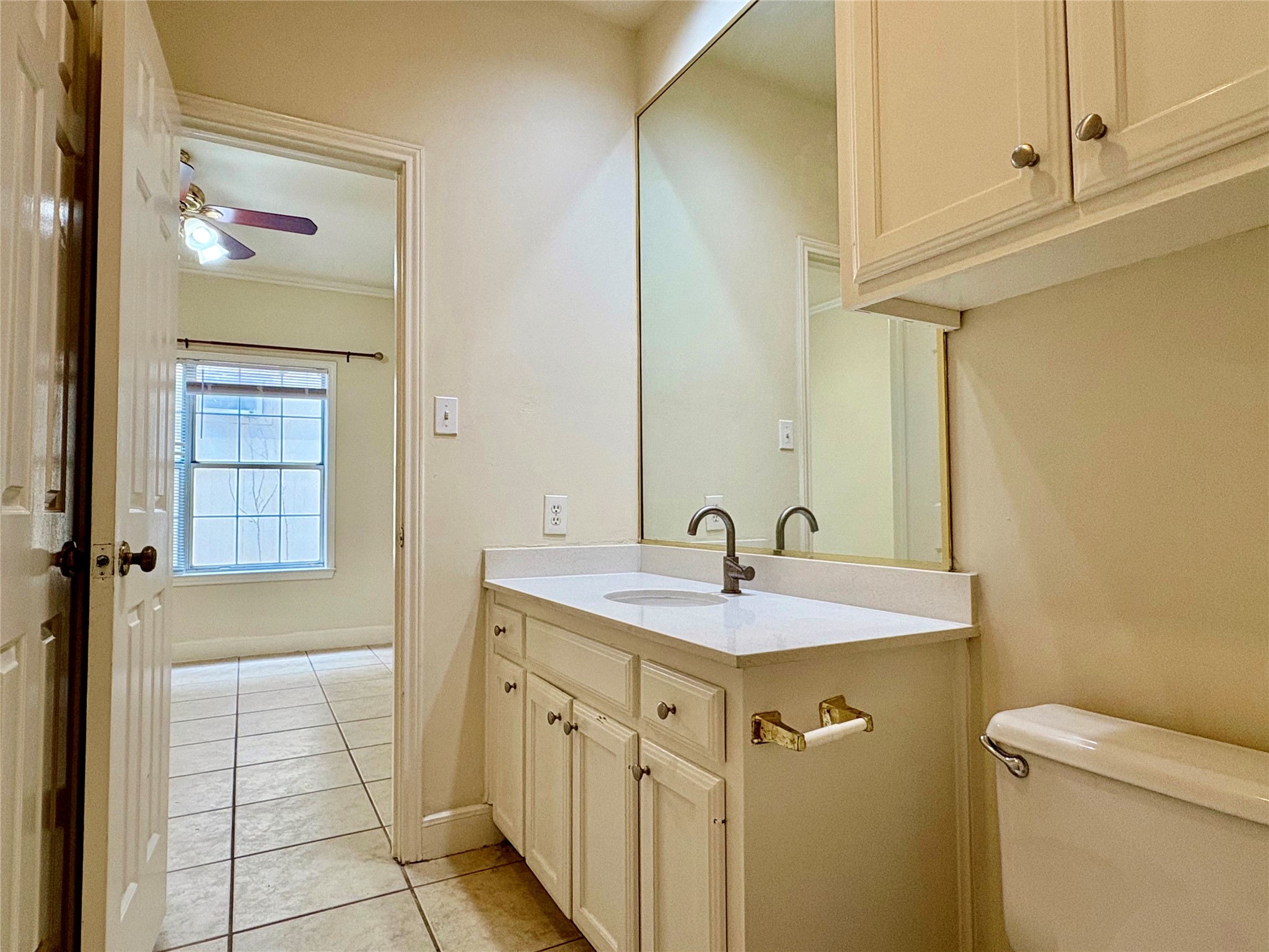 2100 San Gabriel Street, Unit 104 Austin, TX 78705 - Photo 6 of 8 Half bathroom with vanity, light tile patterned floors, and crown molding