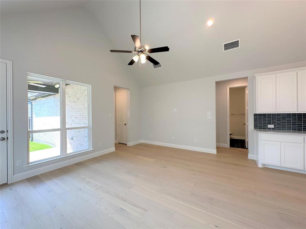 15621 Fringe Tree Road Frisco, TX 75035 - Photo 5 of 18 Unfurnished living room featuring light wood-type flooring, high vaulted ceiling, and a ceiling fan