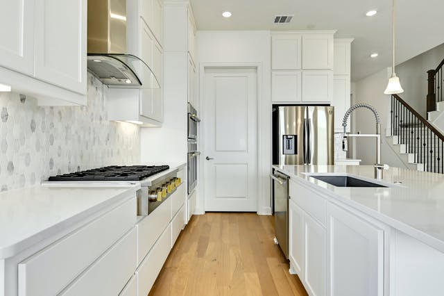 19005 Fernando Trail Austin, TX 78738 - Photo 7 of 26 White Kitchen with hanging light fixtures, white cabinetry, light wood-style flooring, and stainless steel appliances