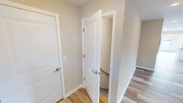 a view of a hallway with wooden floor and staircase