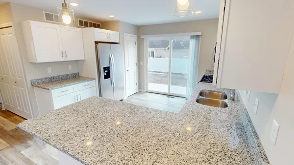 a kitchen with stainless steel appliances granite countertop a refrigerator and a sink