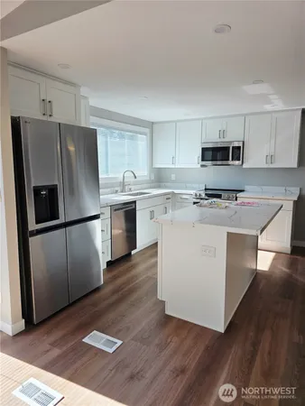 a view of kitchen with sink and refrigerator