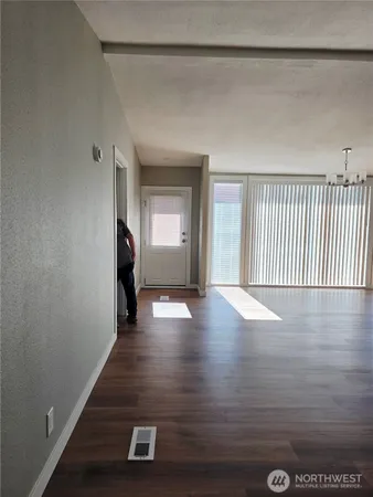 a view of an empty room with wooden floor