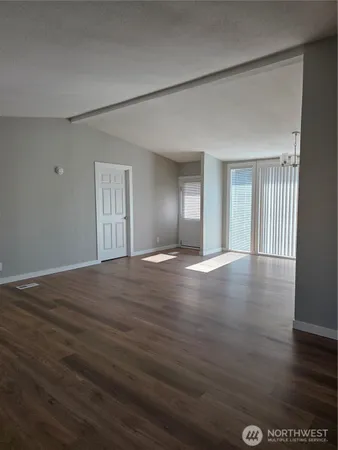 a view of empty room with wooden floor
