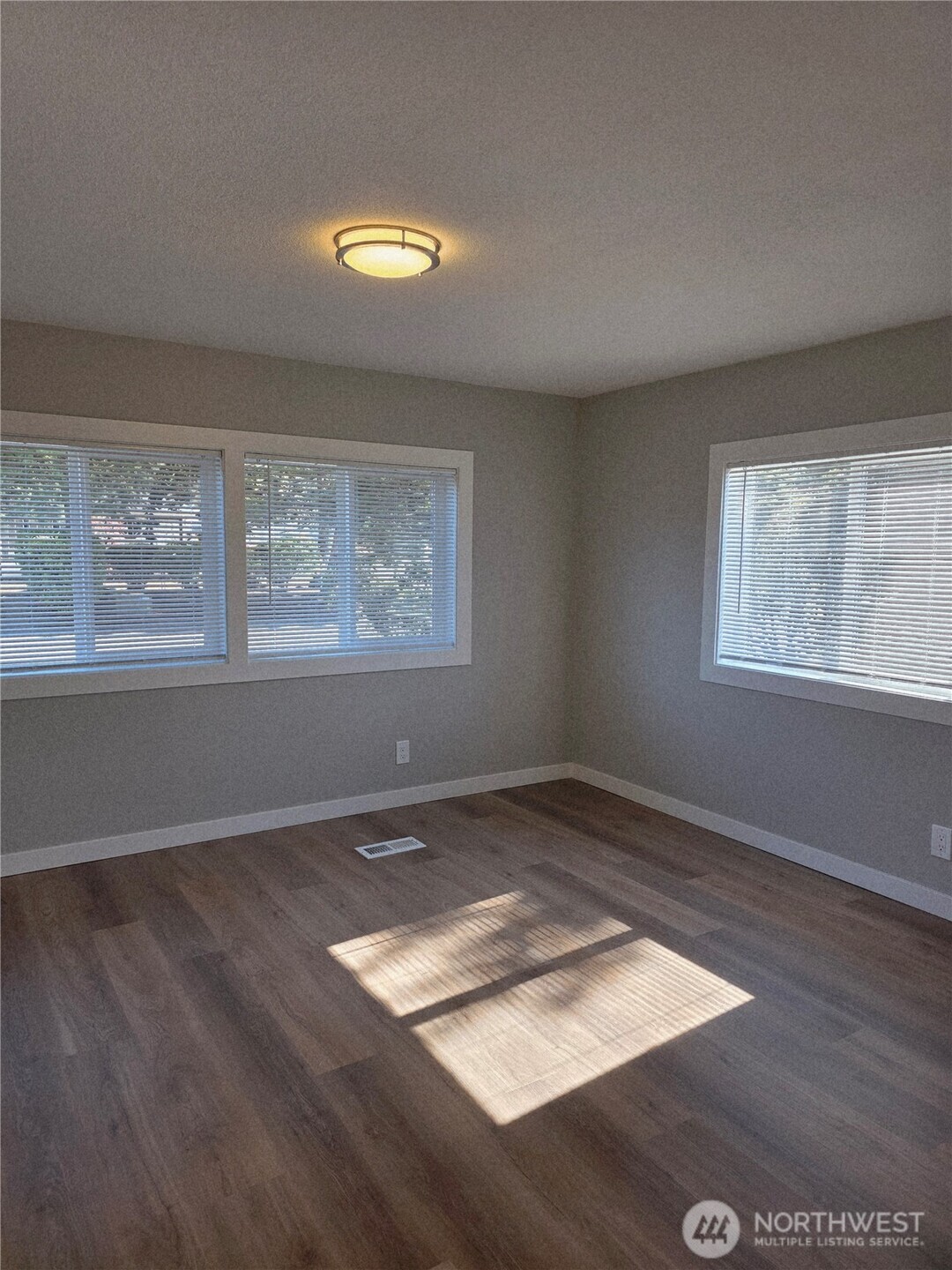 836 South Harmon Way, Unit 73 Orting, WA 98360 - Photo 19 of 30 an empty room with wooden floor and windows