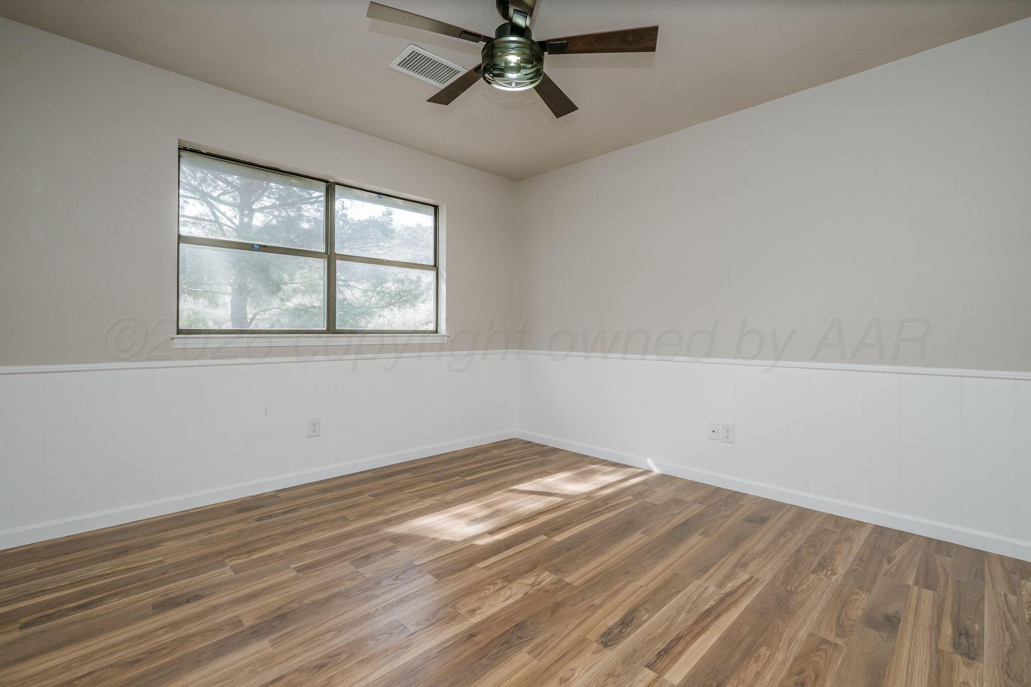 15 Lancaster Road Amarillo, TX 79124 - Photo 30 of 59 an empty room with wooden floor chandelier fan and windows