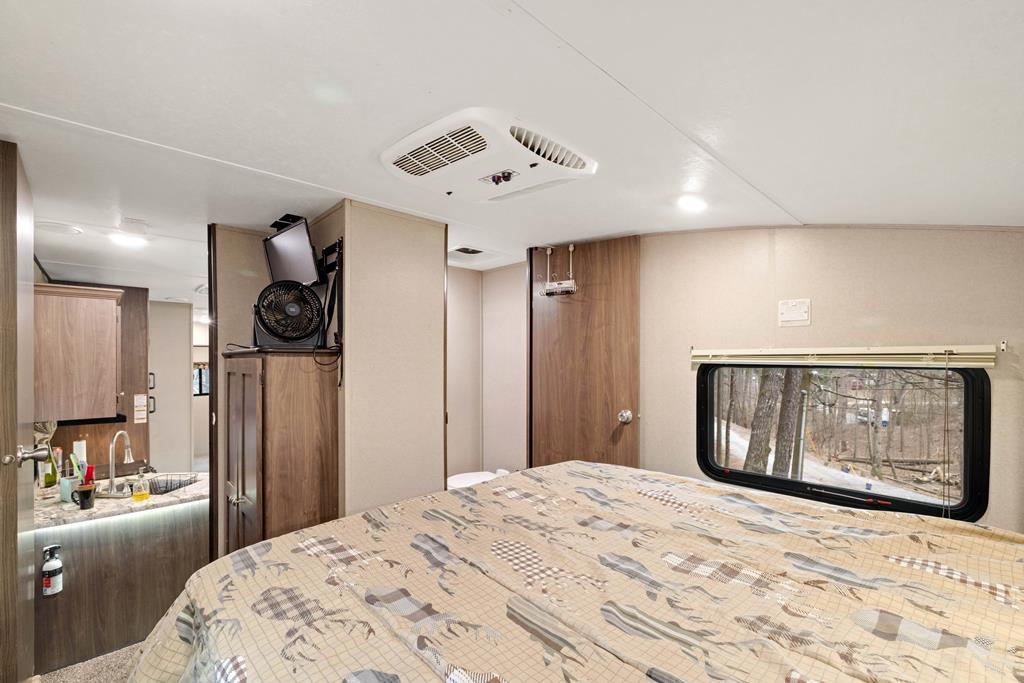 341 25th Street Ellijay, GA 30540 - Photo 10 of 15 a bedroom with a bed and a large mirror with a wooden floor