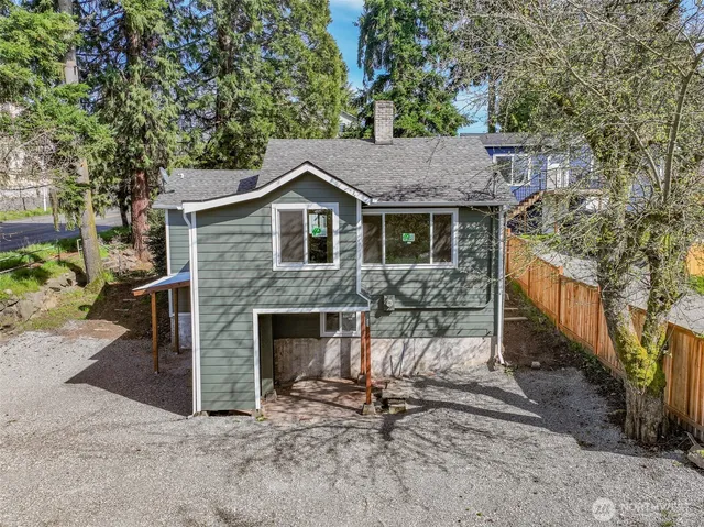 a view of a house with a yard and lawn chairs under an umbrella