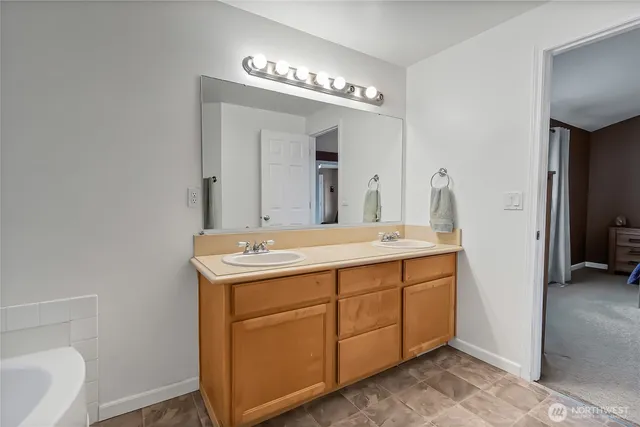 a spacious bathroom with a double vanity sink and a mirror