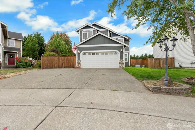 a view of a house with a yard and large trees