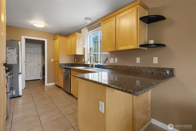 a kitchen with stainless steel appliances granite countertop a sink a stove and a refrigerator